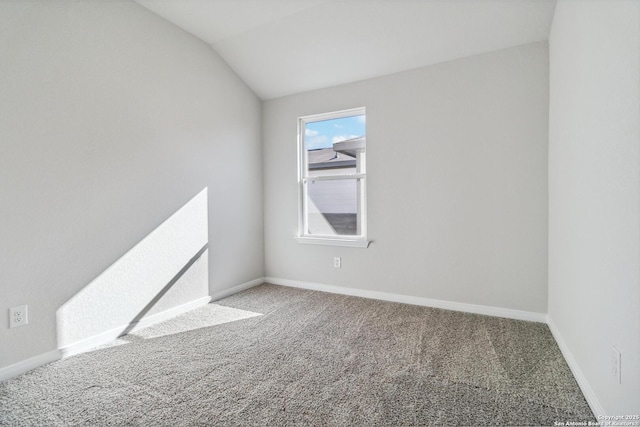 carpeted empty room with lofted ceiling