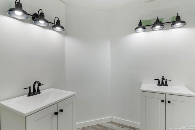 202 Cedar Hill Rd, Pipe Creek, TX 78063 - bathroom with two vanities, wood finished floors, and a sink