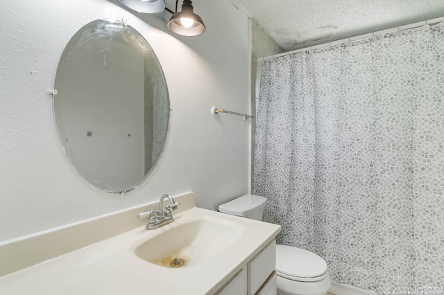 bathroom featuring a textured ceiling, toilet, and vanity