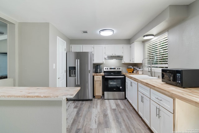 kitchen featuring stainless steel appliances, sink, white cabinetry, light hardwood / wood-style floors, and light stone counters