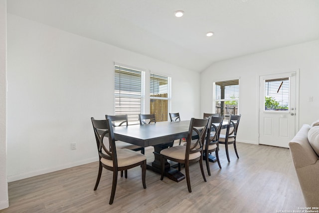 dining area featuring light wood-type flooring and lofted ceiling