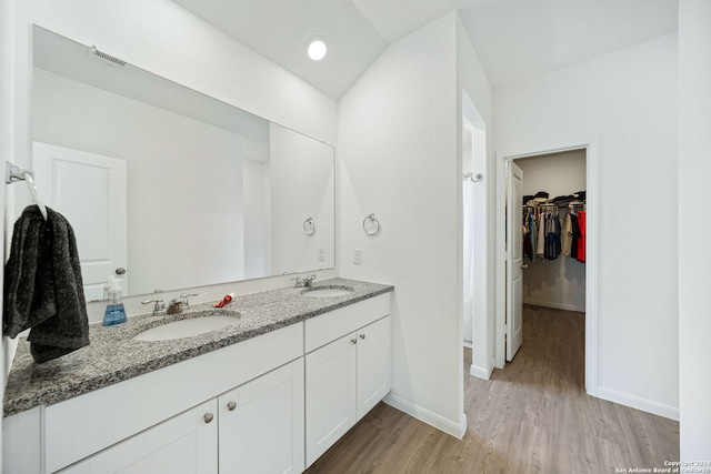 bathroom with hardwood / wood-style floors and dual vanity