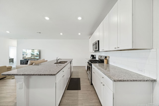 kitchen with light hardwood / wood-style flooring, sink, stainless steel appliances, and white cabinets