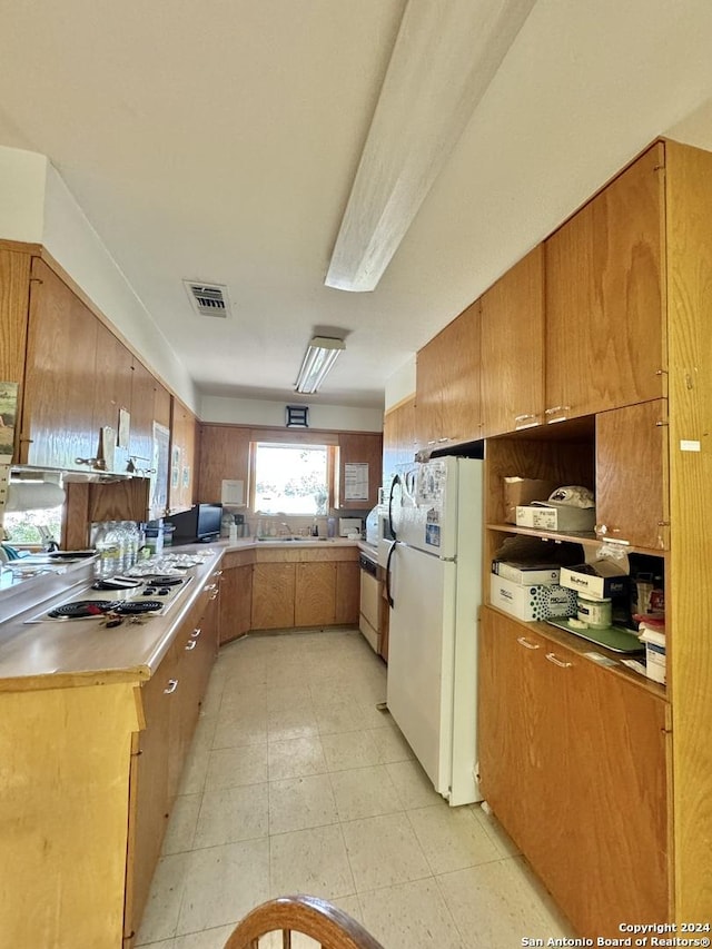 kitchen with sink, kitchen peninsula, and white refrigerator