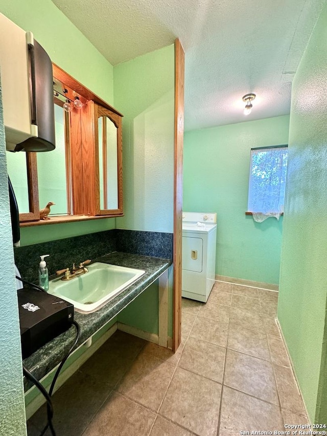 bathroom with tile patterned floors, washer / clothes dryer, sink, and a textured ceiling