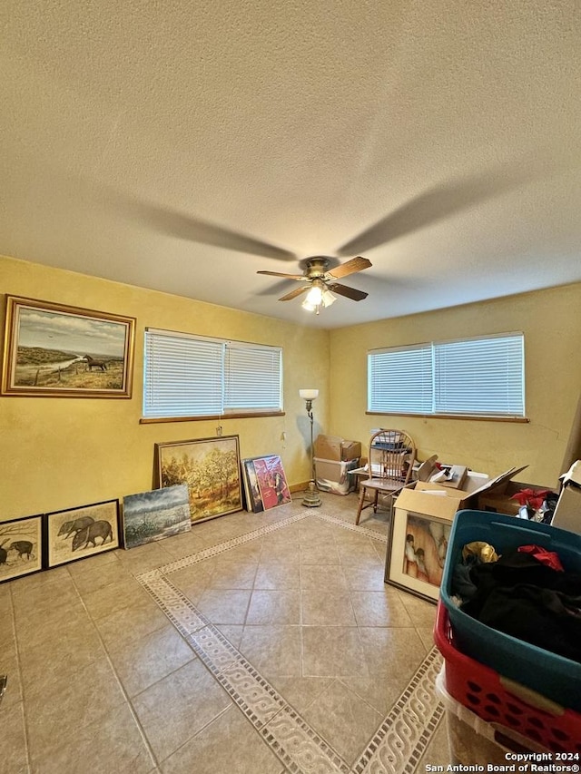 playroom with ceiling fan, tile patterned floors, and a textured ceiling