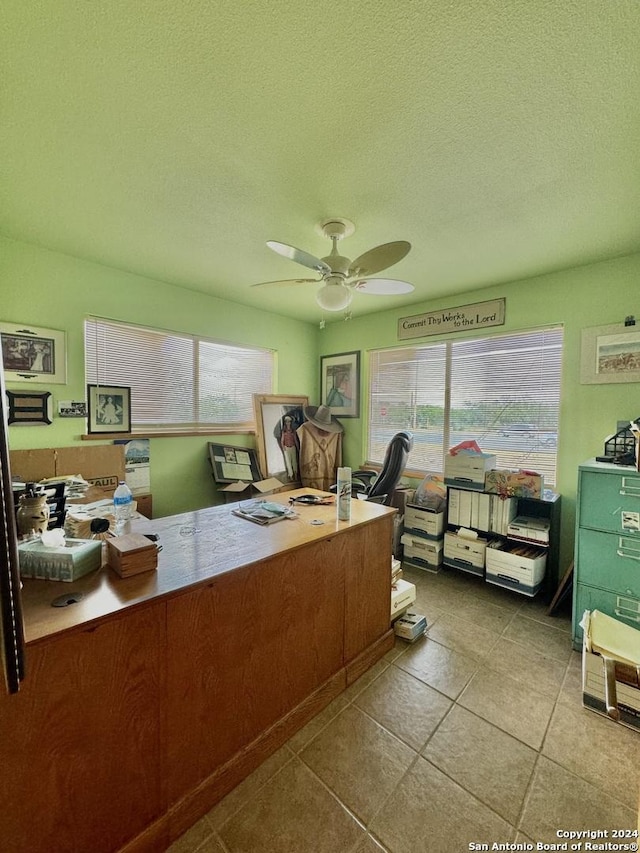 home office featuring ceiling fan, light tile patterned floors, and a textured ceiling