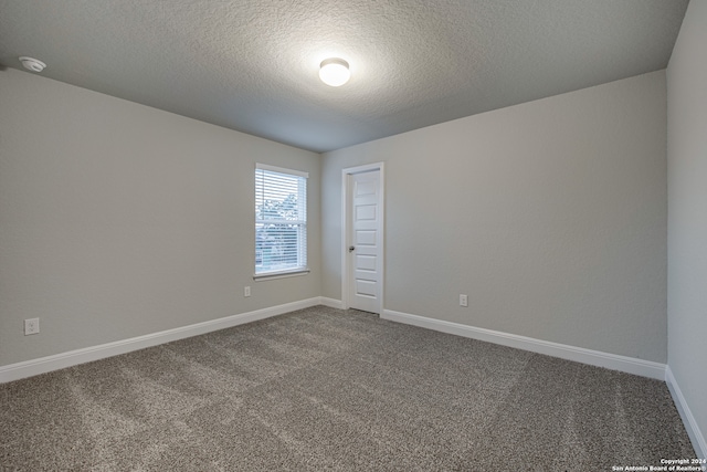 carpeted empty room with a textured ceiling