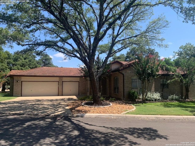 view of front of property with a tile roof, driveway, and an attached garage