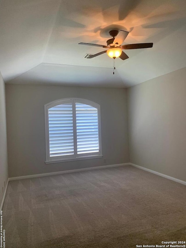 carpeted empty room with vaulted ceiling and ceiling fan