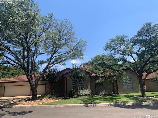 view of front of home with driveway, an attached garage, and a front yard