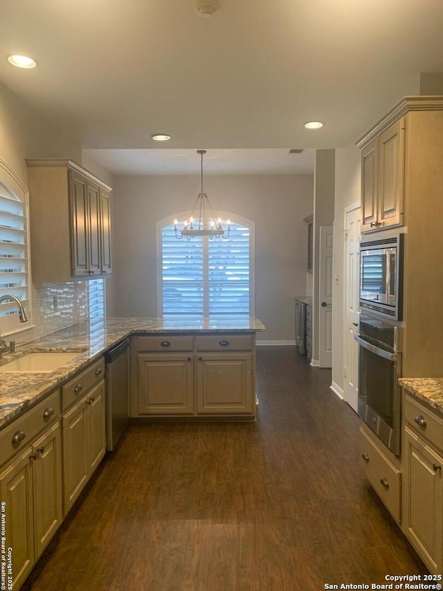 kitchen featuring dark wood-style floors, stainless steel appliances, visible vents, a sink, and a peninsula