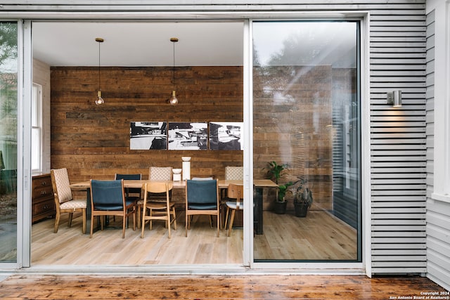 interior space with hardwood / wood-style flooring and wood walls