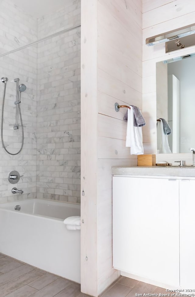 bathroom featuring tiled shower / bath and vanity