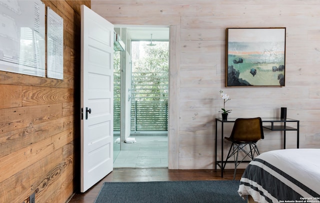 bedroom featuring wooden walls and dark hardwood / wood-style flooring