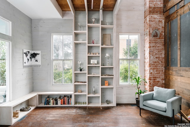 living area featuring hardwood / wood-style floors, wooden walls, and plenty of natural light