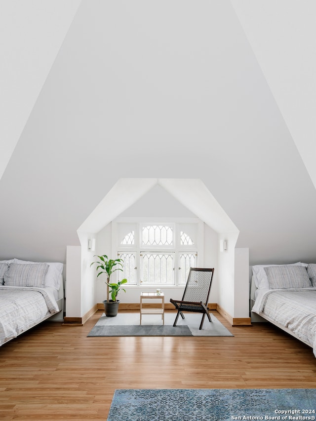 bedroom with hardwood / wood-style flooring and lofted ceiling