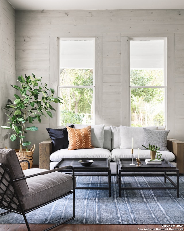 living room with hardwood / wood-style flooring and wooden walls