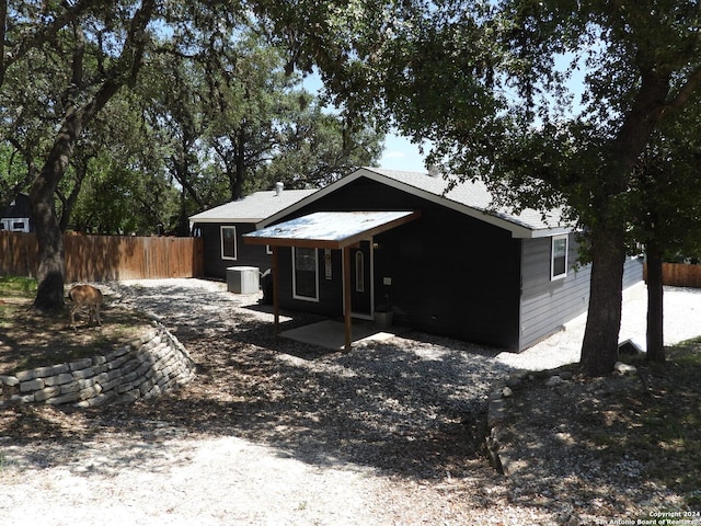 view of front of home featuring central air condition unit and fence