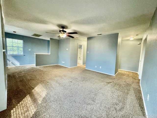 carpeted spare room with a textured ceiling and ceiling fan