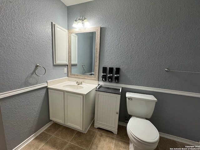 bathroom with toilet, tile patterned floors, and vanity