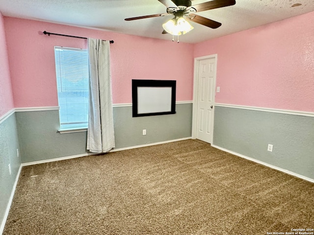 empty room featuring ceiling fan and carpet