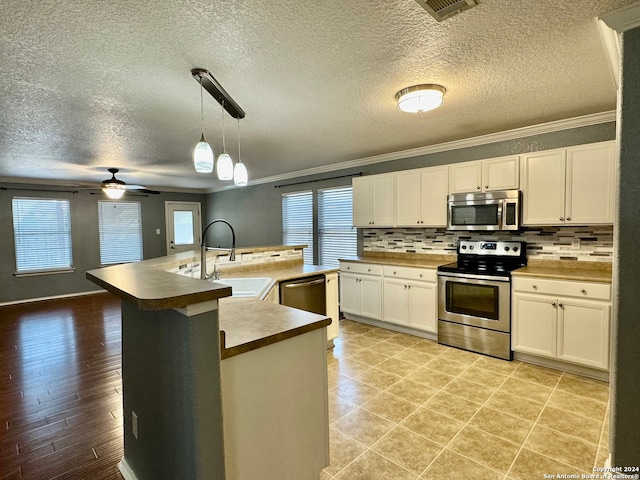 kitchen featuring light hardwood / wood-style flooring, stainless steel appliances, ceiling fan, and a healthy amount of sunlight