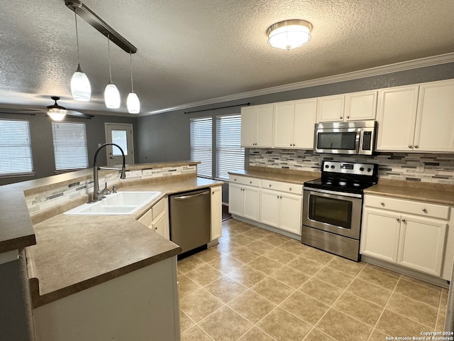 kitchen featuring crown molding, pendant lighting, appliances with stainless steel finishes, ceiling fan, and plenty of natural light