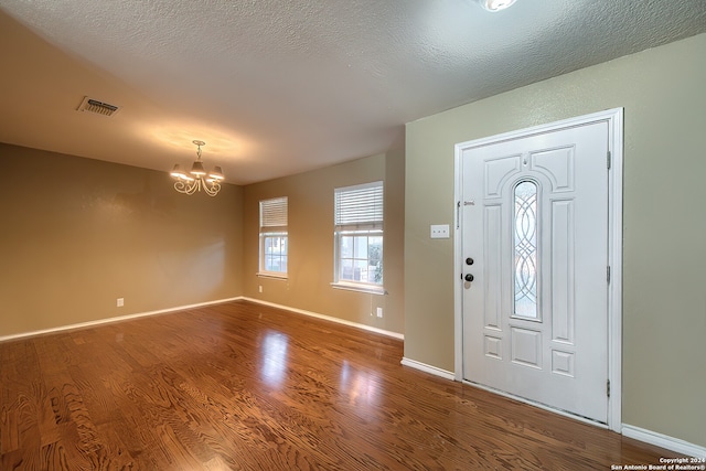 entrance foyer featuring wood-type flooring, a chandelier, and a textured ceiling