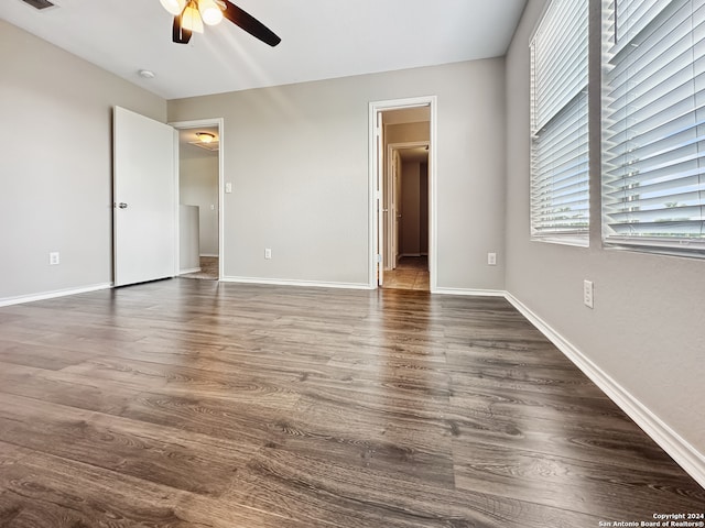 unfurnished bedroom featuring ceiling fan, ensuite bathroom, and hardwood / wood-style floors