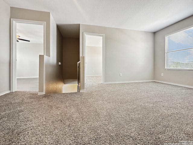 unfurnished room featuring ceiling fan, a textured ceiling, and carpet floors