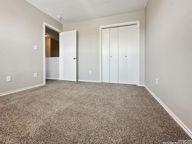 unfurnished bedroom featuring carpet flooring and a closet