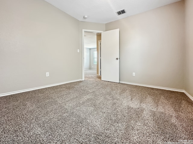 carpeted empty room with a textured ceiling