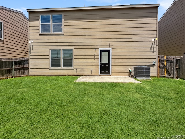 back of house with central air condition unit, a yard, and a patio area