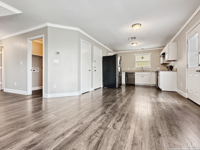 interior space featuring ornamental molding, stainless steel appliances, hardwood / wood-style flooring, and white cabinetry