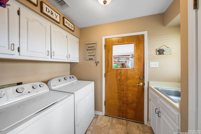 laundry room with cabinets, sink, and washing machine and dryer