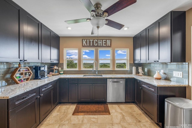 kitchen featuring a healthy amount of sunlight, sink, light stone counters, and decorative backsplash