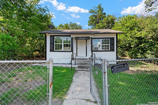 bungalow-style home with a fenced front yard, a gate, and a front yard