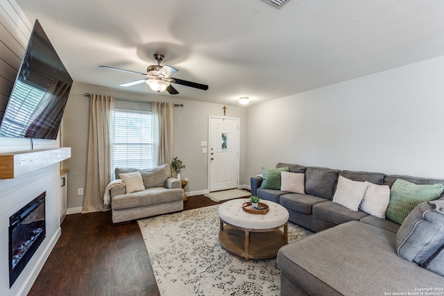 living room featuring ceiling fan and dark hardwood / wood-style floors