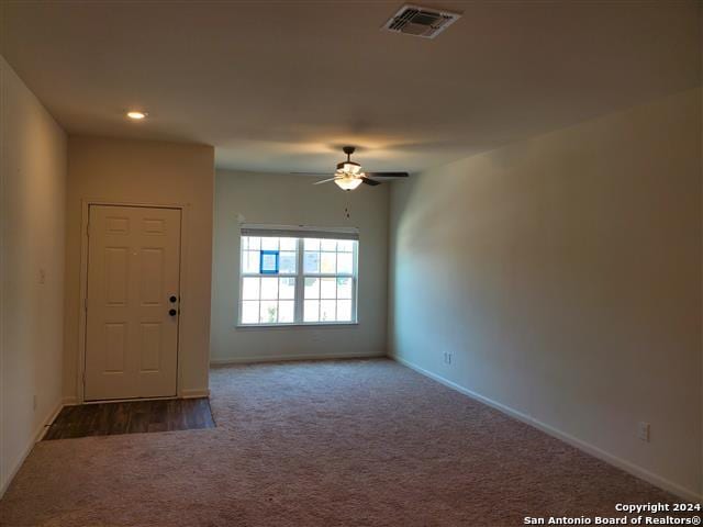 empty room with ceiling fan and carpet