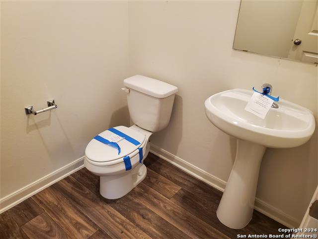 bathroom with hardwood / wood-style flooring and toilet