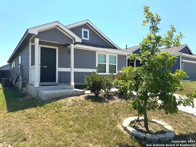 view of front of home with a porch, a front lawn, and cooling unit