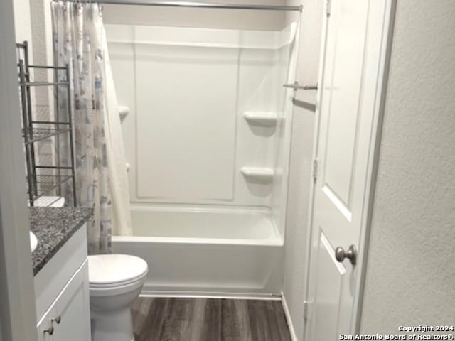 full bathroom featuring toilet, hardwood / wood-style flooring, shower / tub combo with curtain, and vanity