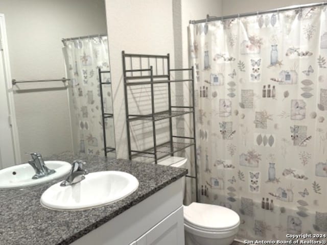 bathroom featuring vanity, toilet, and curtained shower