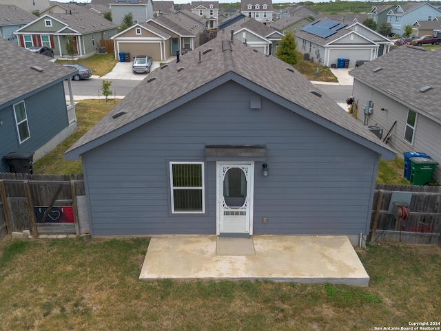 back of house with a garage, a patio area, and a yard