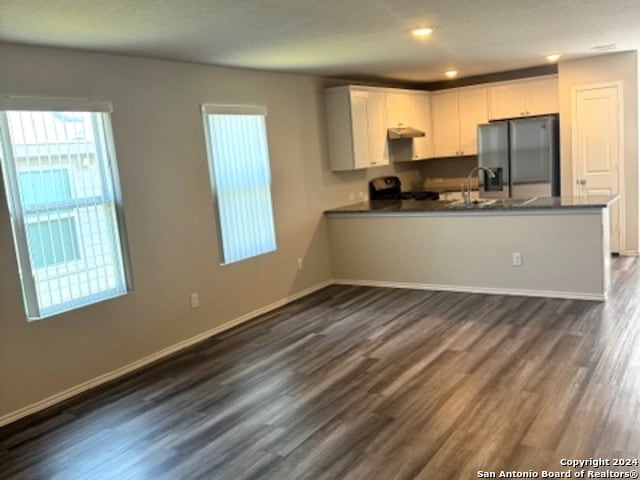 kitchen featuring kitchen peninsula, white cabinetry, and stainless steel refrigerator with ice dispenser