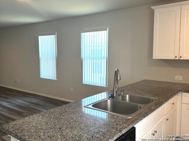 kitchen featuring dark stone counters, white cabinetry, dark hardwood / wood-style flooring, and sink