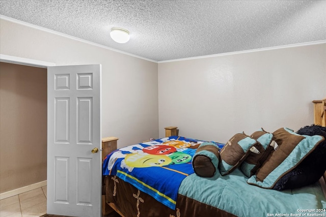 bedroom featuring ornamental molding, a textured ceiling, and light tile patterned floors