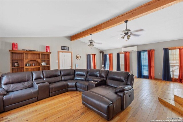 living room featuring a wall unit AC, lofted ceiling with beams, ceiling fan, and light hardwood / wood-style floors