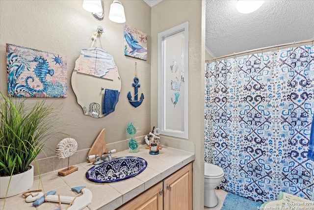 bathroom with a textured ceiling, toilet, and vanity